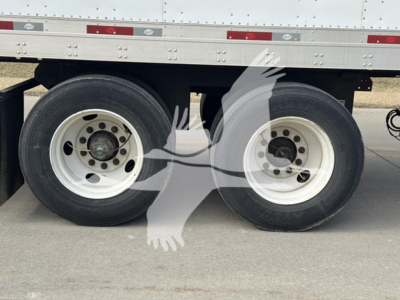 Trailer axles and wheels of a 2014 Utility 4000Dx trailer showing dual rear tires and white rims.