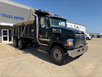 Dump truck with Western Star grille showing black cab and dump bed in a dealership lot. Visible text includes 'TRUCK CENTER' on building, and various stickers on the door area and cab window. Vehicle details on listing include VIN 5KKHAVDV3