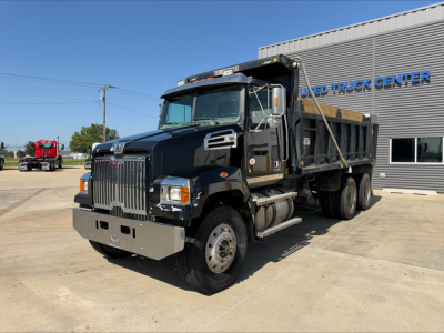 Western Star 4700SF dump truck in service bay showing chrome grille and dual rear wheels.