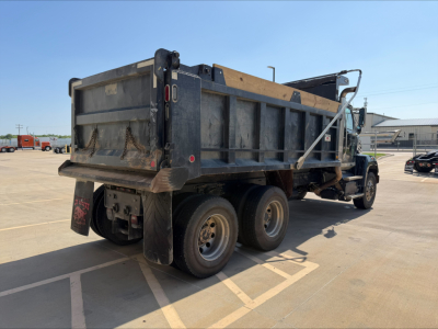 Truck rear view of a 2018 Western Star 4700SF dump truck in a parking lot, showing the dump bed, dual rear axles, taillights, and mud flaps.