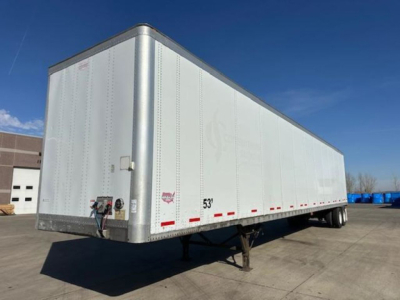 Trailer side view showing a 53-foot white Wabash van trailer with dual rear axles and landing gear in a dealership lot.
