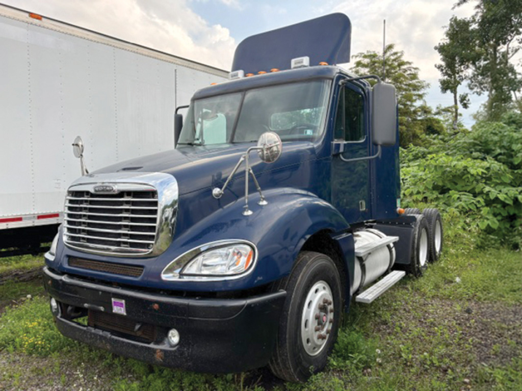 Truck cab and front view of a dark blue 2007 Freightliner CL120 Columbia conventional daycab showing chrome grille, headlights, and side mirrors.