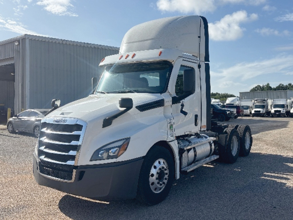 Freightliner Cascadia126 daycab tractor in white, front and side view showing twin rear axle configuration and sleeper cab top, no visible branding text.