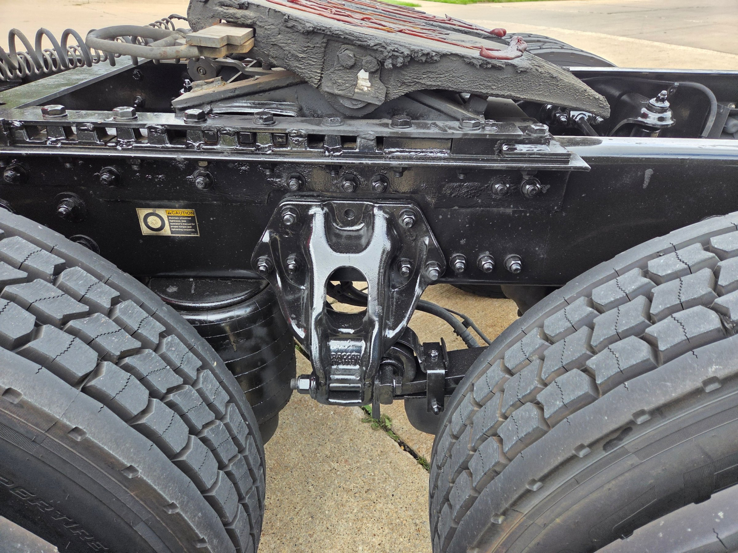 Truck rear view showing fifth wheel hitch and dual rear axles on a Kenworth T680 chassis