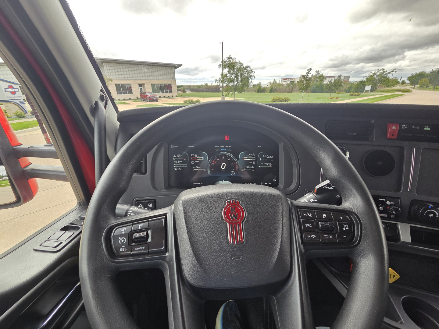 Kenworth T680 interior steering wheel and dashboard view, driver-side with digital gauges and steering wheel controls.