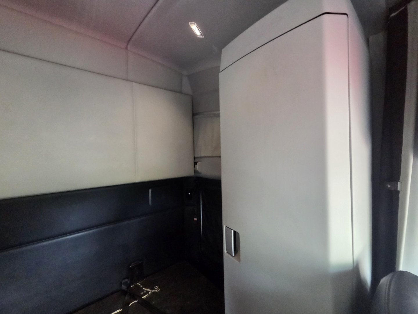 Kenworth T680 sleeper cab interior showing storage cabinet and side panel.