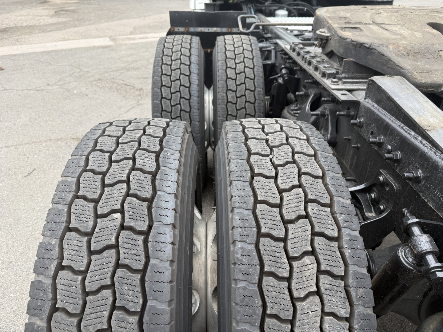 Truck rear view showing dual rear axles and heavy-duty tires on a 2021 International LT625 cab/tractor with visible suspension and frame components.