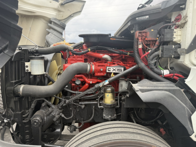 Engine bay of 2021 International LT625 showing Cummins X15 engine label and surrounding hoses and components.