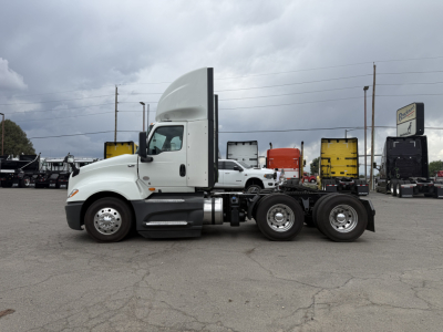 Truck cab and chassis showing International LT625 badge area and twin rear axles in a lot.