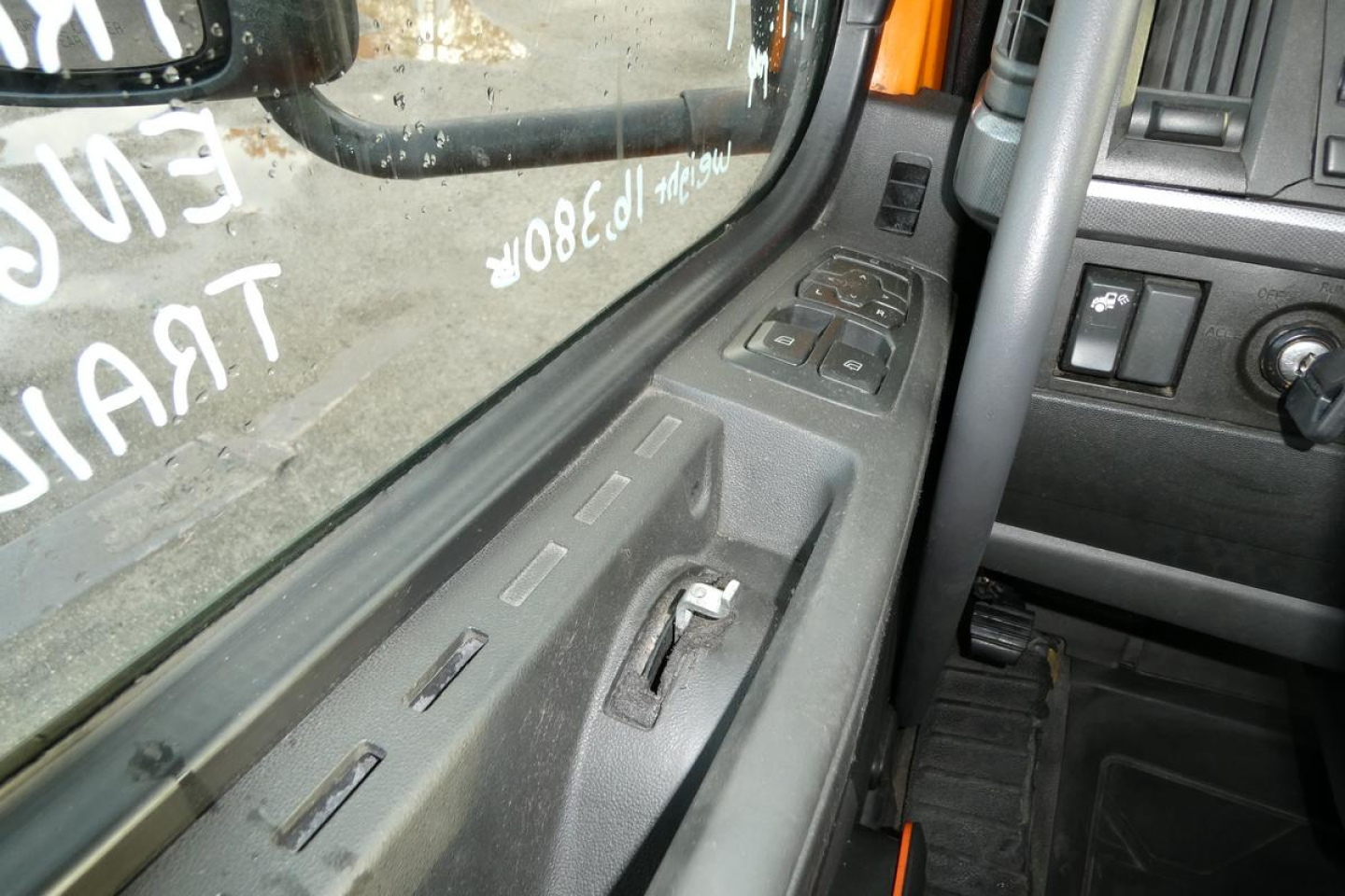 Truck cab interior window and door panel with window controls visible.