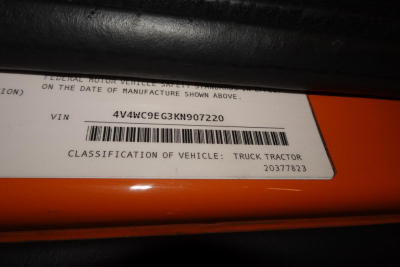 VIN label on orange truck frame showing VIN 4V4WC9EG3KN907220 and classification text underneath.