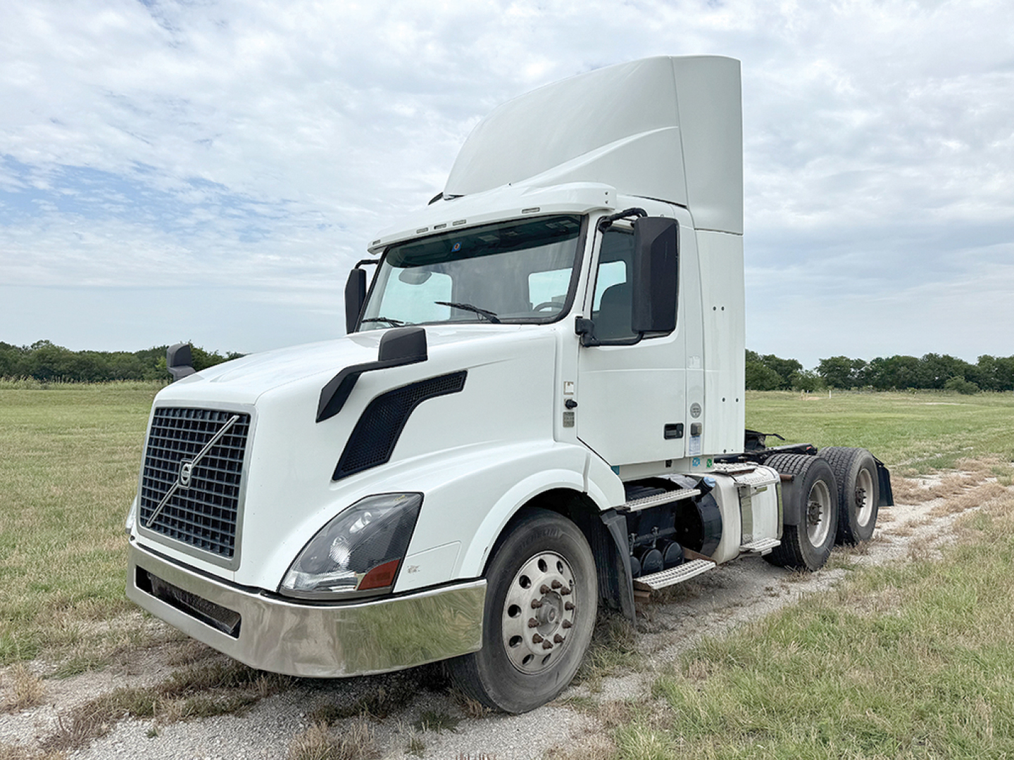 Volvo VNL 300 tractor cab truck in field showing front-left view with sleeper cab and dual rear axles.