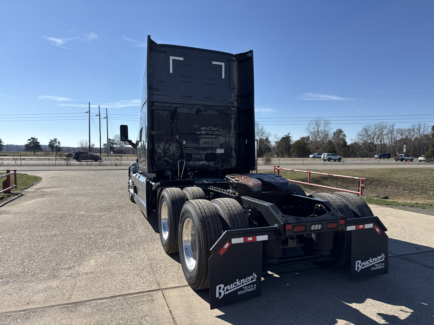 Truck rear view showing Mack PR64T76H sleeper with dual rear axles and mud flaps
