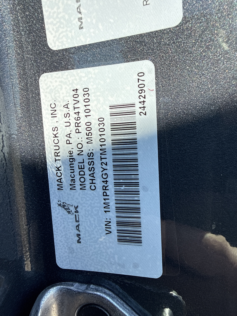Mack Trucks label with VIN and model info: 'MACK TRUCKS, INC. MACDON... MACK TRUCKS, INC. MACK TRUCKS, INC. MACH... CHASSIS NO: 5... VIN: 1MPR4GY2TM101030' plus barcode and numbers; sticker shows '244929070'