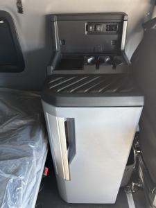 Truck cab interior showing center console with USB/12V ports and storage compartment in a Mack PR64T76H