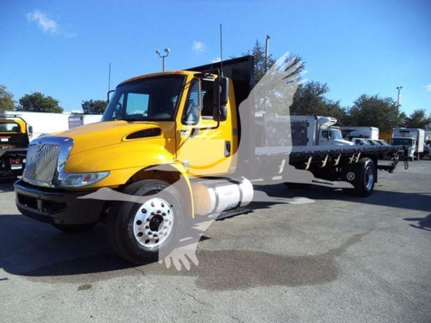 2019 International Durastar 4300 flatbed truck shown in a dealership lot with yellow cab and black dump-style bed.