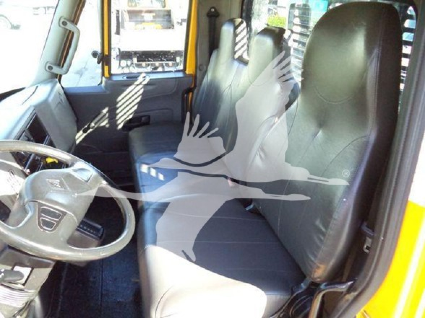 Interior of a 2019 International Durastar 4300 flatbed truck showing front seats, steering wheel, and dashboard.