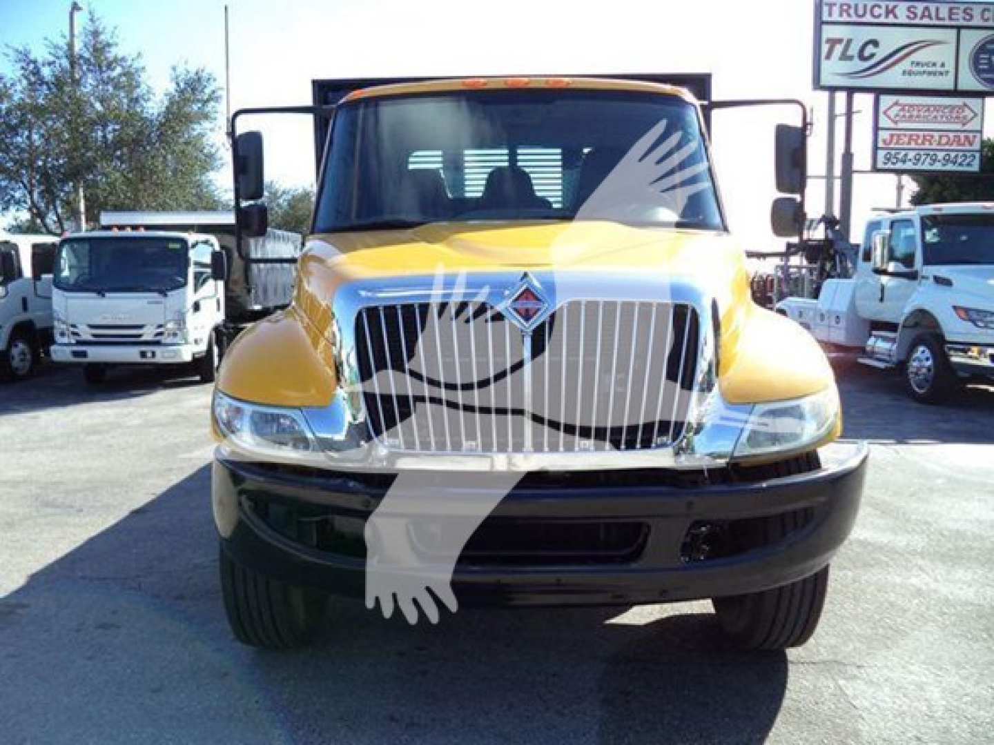Interational Durastar 4300 flatbed truck front view showing yellow cab and large chrome grille.