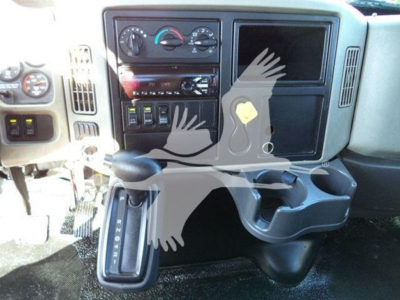 Dashboard area of a 2019 International Durastar 4300 with center console, gear selector, control knobs, cup holders, and empty screen slot.