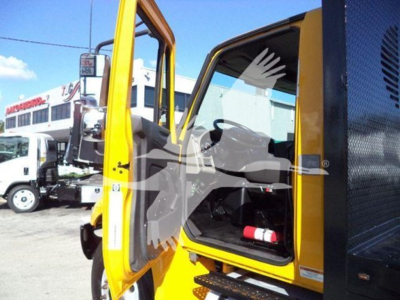 International Durastar 4300 truck cab interior visible through open door with yellow frame and black interior, nearby trucks in lot.