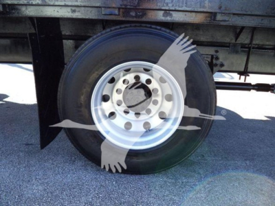 Wheel of a flatbed truck showing a steel rim and black tire; faint watermark overlay with birds in flight.