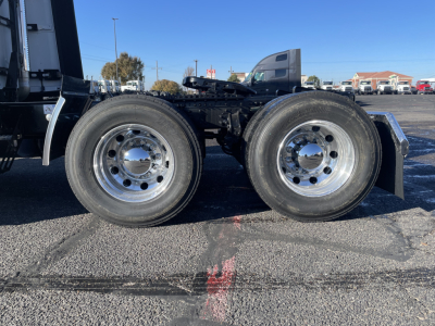 Dual rear axles of a Mack PR64T76H truck showing tandem wheels and chrome hubcaps.