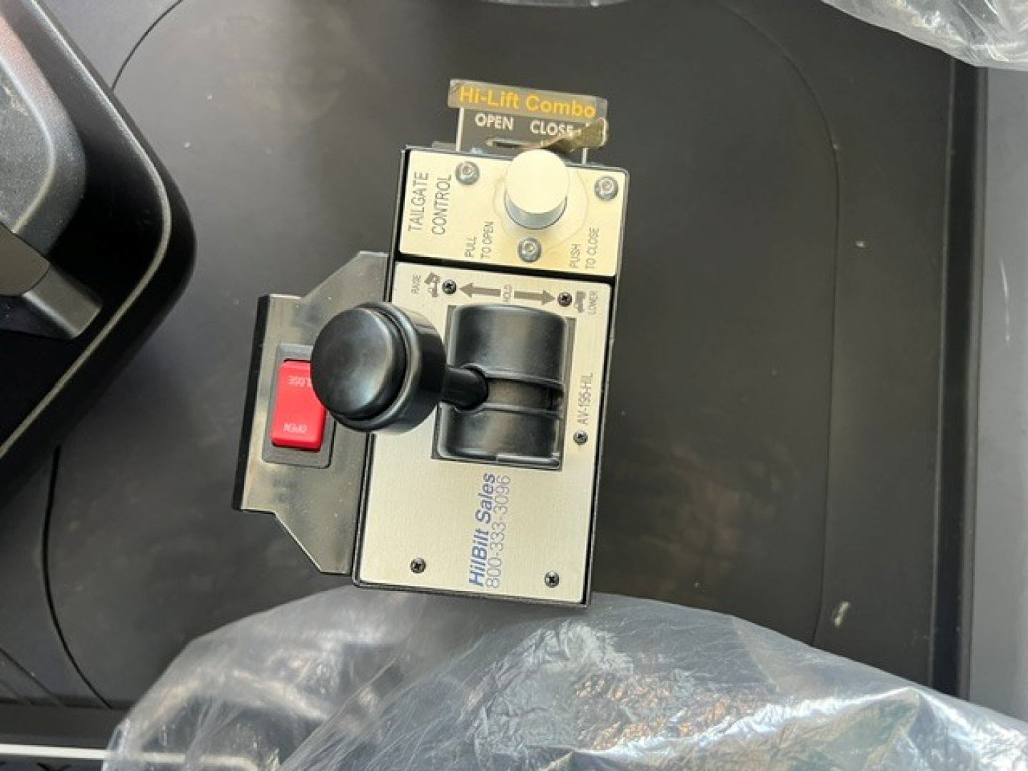 Console control panel with toggle switch, joystick, and label text. Visible text includes 'Hi-Lift Combo', 'OPEN', 'CLOSE', 'TILTING', 'TRAILER CABLE', 'GUIDE', 'SOLID', and 'Hillbill Sails' (likely 'Hillbill Sales' on the side). The panel