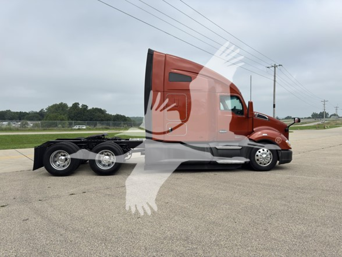 Kenworth T680 tractor cab side view showing red/brown exterior and sleeper cab, with chassis and dual rear axles, no trailer attached.