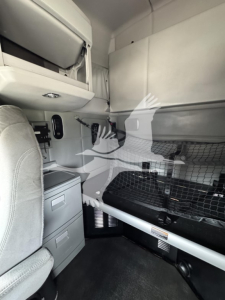 Cab interior of a 2019 Kenworth T680 sleeper showing bunk area, storage drawers, and overhead compartments.
