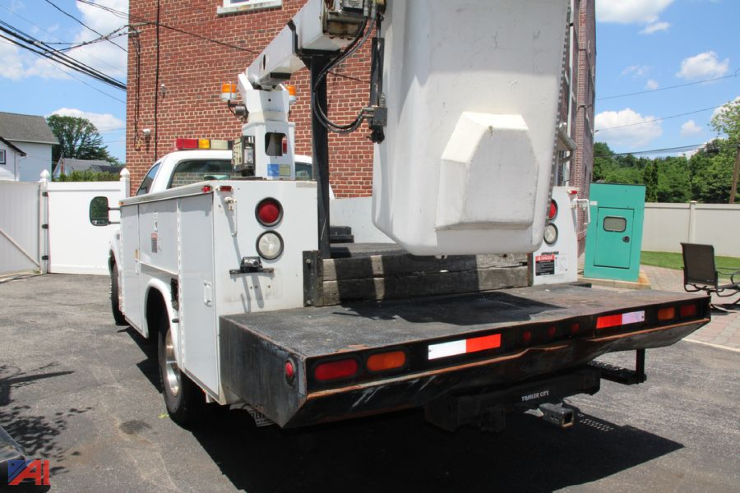 Truck bucket boom service body showing rear view with bucket lift and utility controls on a white Ford F-350 bucket truck.