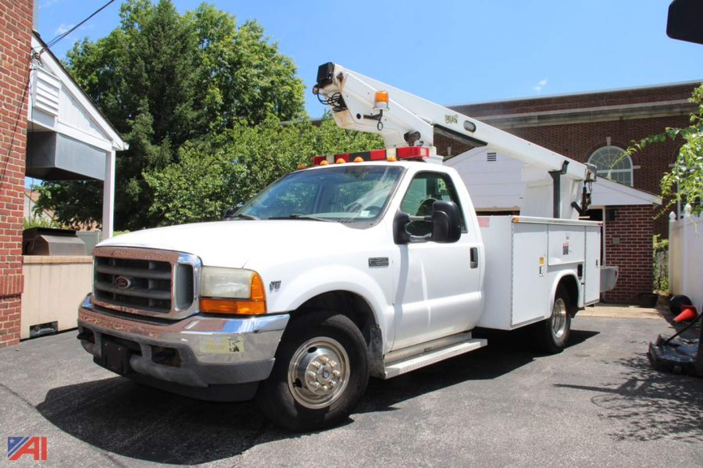 Ford F-350 Super Duty bucket truck with boom lift in service bay, front three-quarter view.