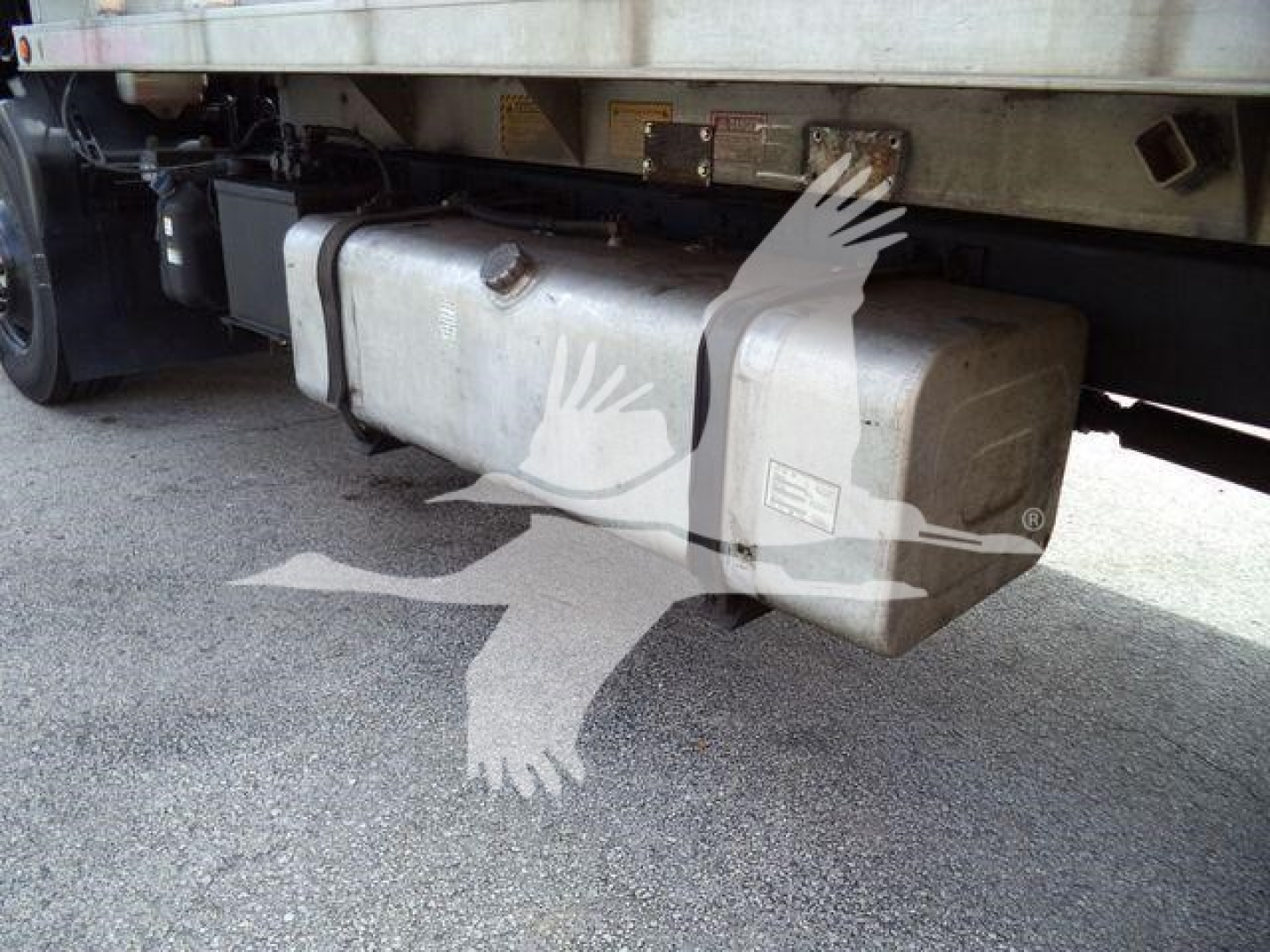 Isuzu FTR truck undercarriage showing a large rectangular fuel tank/auxiliary tank with mounting straps.