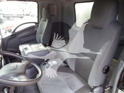 Isuzu truck interior showing driver and passenger seats with steering wheel and dashboard visible.