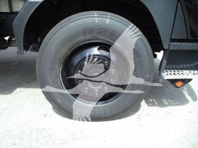 Truck wheel and fender showing front tire with rim and wheel well.