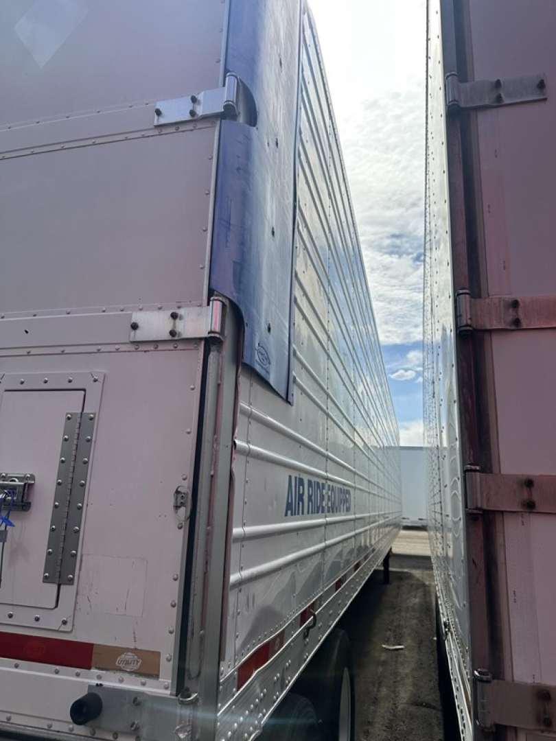 Trailer side view of a 2015 Utility 3000R reefer trailer showing metal siding with latches and corner posts.