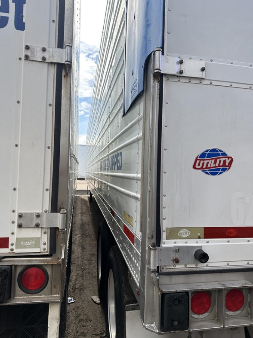 Trailer side view of two Utility 3000R refrigerated trailers showing rear doors and Utility logo on right trailer.