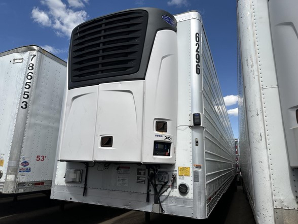 2015 Utility 3000R trailer refrigeration unit with Ferm logo at top, side doors, and vertical numbers; docked among similar trailers.