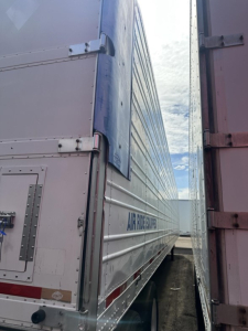 Trailer side view of a 2015 Utility 3000R reefer trailer showing metal siding with latches and corner posts.