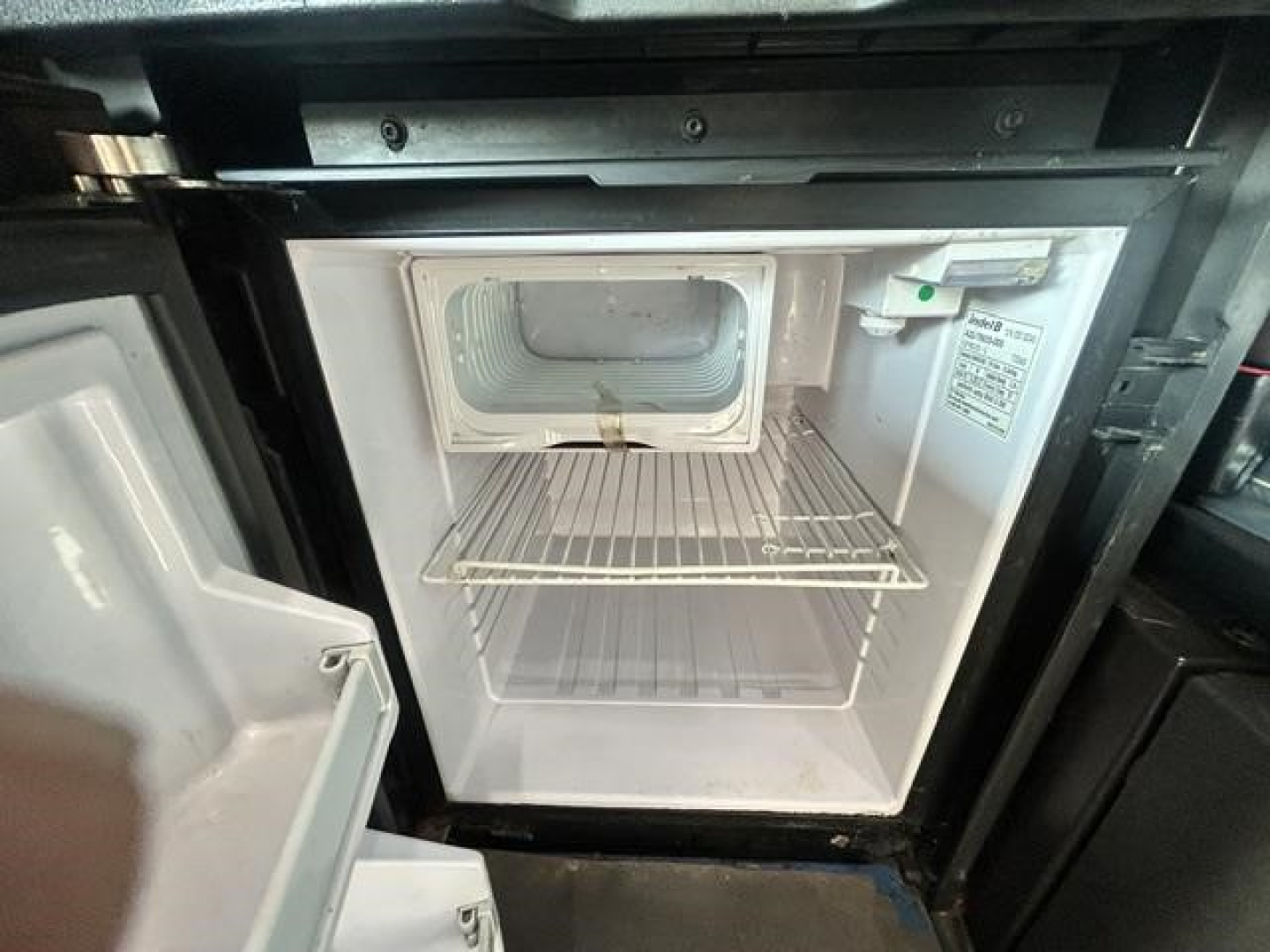 Freightliner Cascadia 126 engine bay showing empty refrigerator/freezer unit and interior compartments.