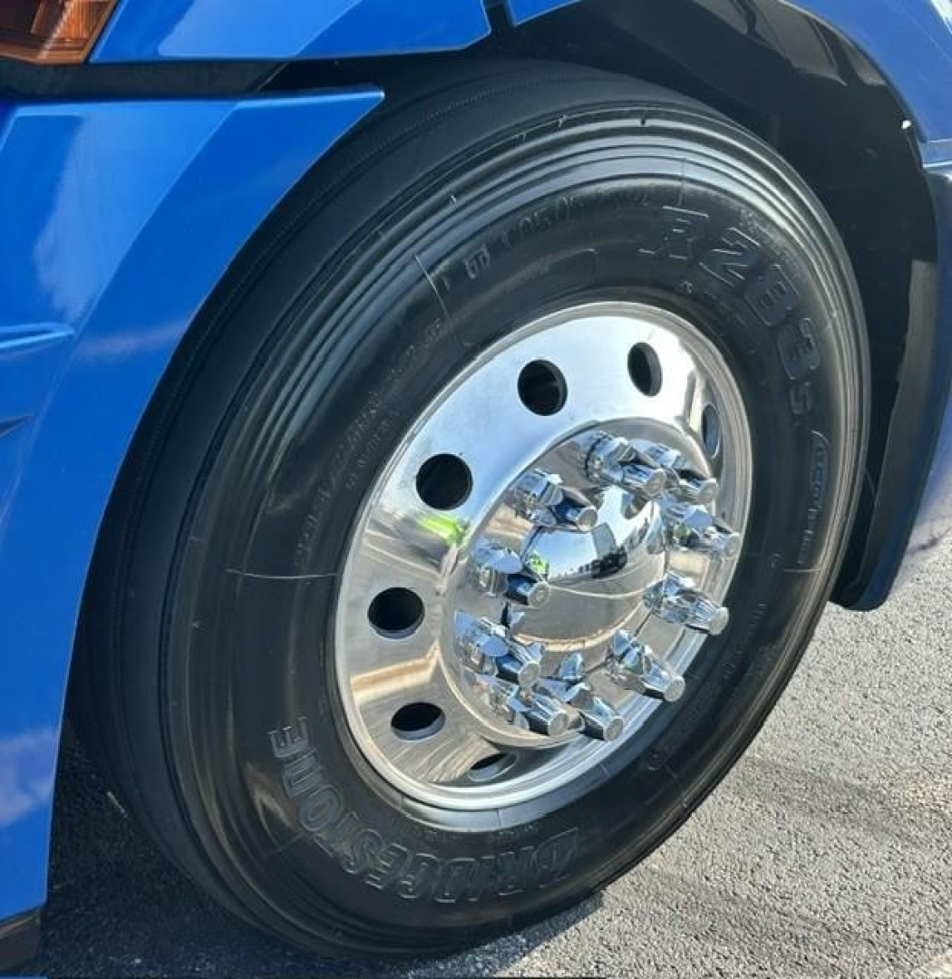 Truck wheel and tire close-up showing steel polished hubcap and Bridgestone tire on Freightliner Cascadia 126