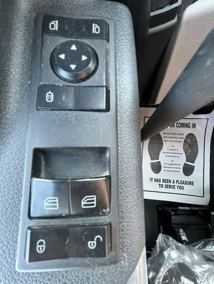 Truck interior controls panel with window and mirror adjustment buttons in view. Text not visible beyond control icons.