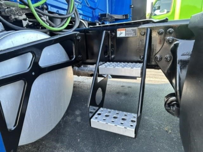 Freightliner Cascadia 126 chassis side showing aluminum steps and frame with tanks and wiring.