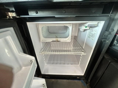 Freightliner Cascadia 126 engine bay showing empty refrigerator/freezer unit and interior compartments.