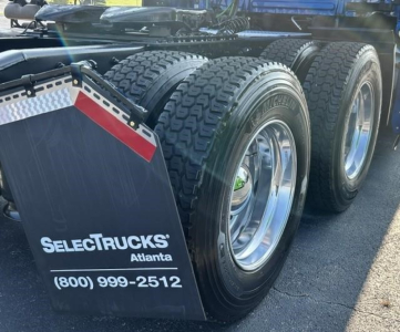 Triple-axle Freightliner Cascadia rear view showing fuel tanks and wheels, Select Trucks Atlanta mudflap with phone number.