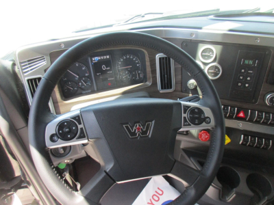 Steering wheel and dashboard of a new 2027 Western Star 49X dump truck showing instrument cluster, controls, and logo.