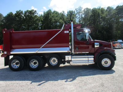 Western Star 49X dump truck side view showing red dump body, chrome fuel tanks, and multiple rear axles.