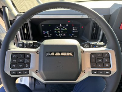 Mack PR64T dashboard steering wheel view showing digital instrument cluster and steering wheel controls.