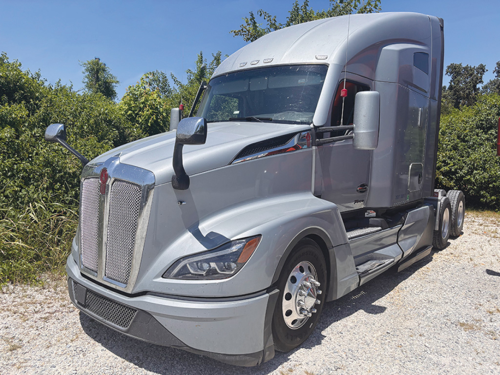 Truck cab showing Kenworth T680 Next Gen sleeper with silver exterior and large grille.