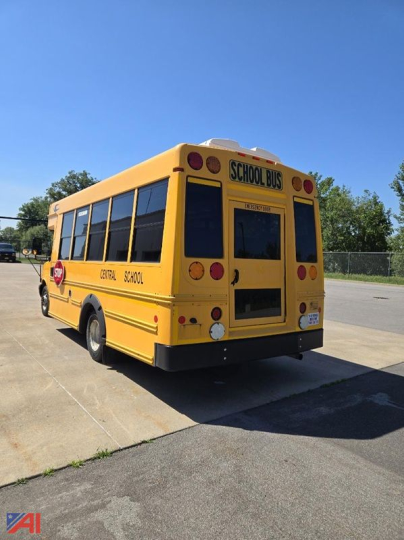 Rear-right view of a yellow 2018 Chevrolet Express G4500 mini school bus with 'SCHOOL BUS' signs and black tinted windows.