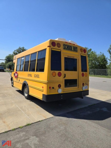 Rear-right view of a yellow 2018 Chevrolet Express G4500 mini school bus with 'SCHOOL BUS' signs and black tinted windows.